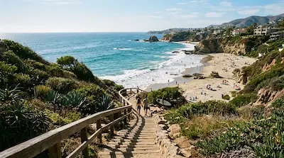 A wooden staircase and path leading down to a Laguna Beach cove, ocean and coastal bluffs beyond.